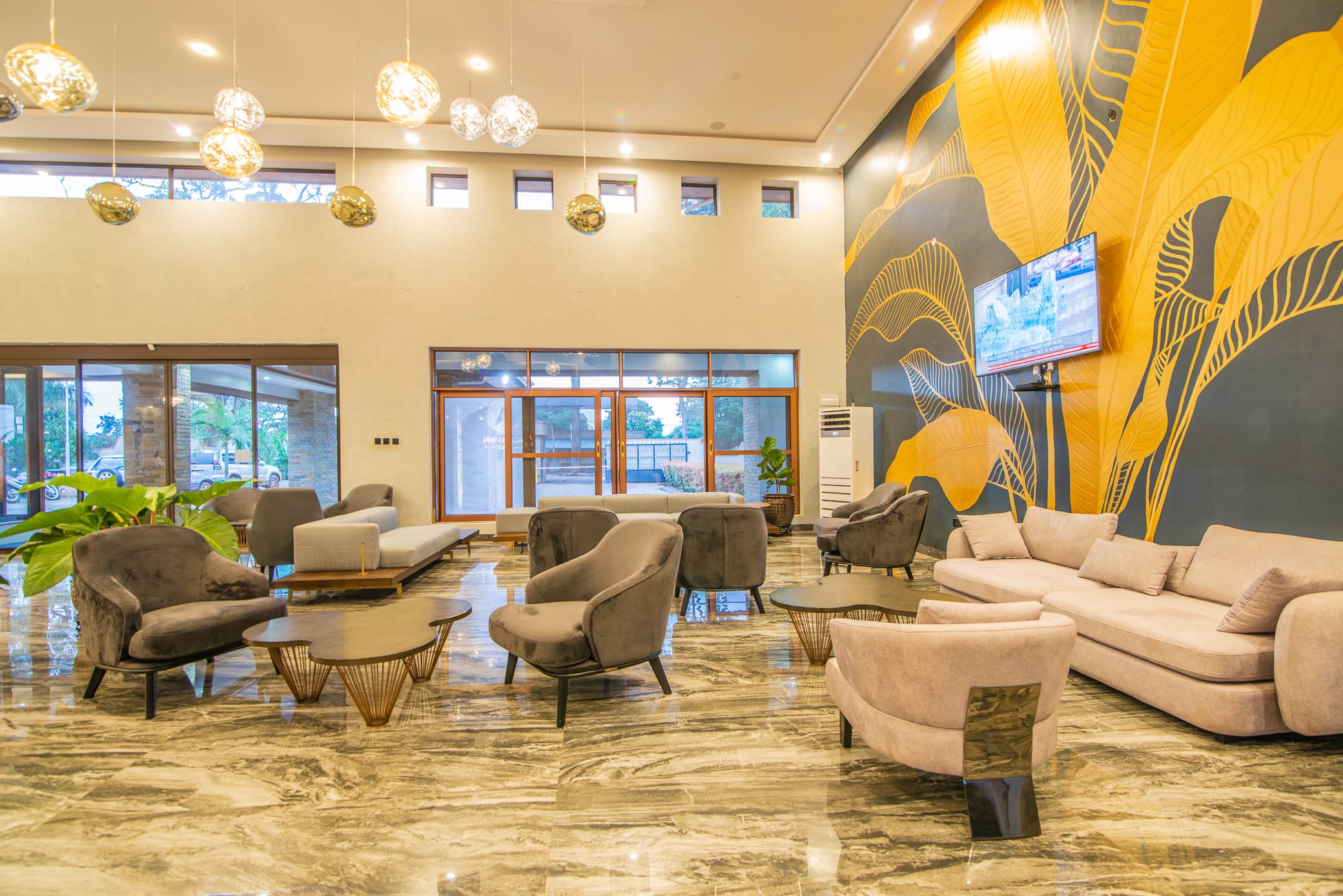 Guest lounge with armchairs beneath the leaf mural